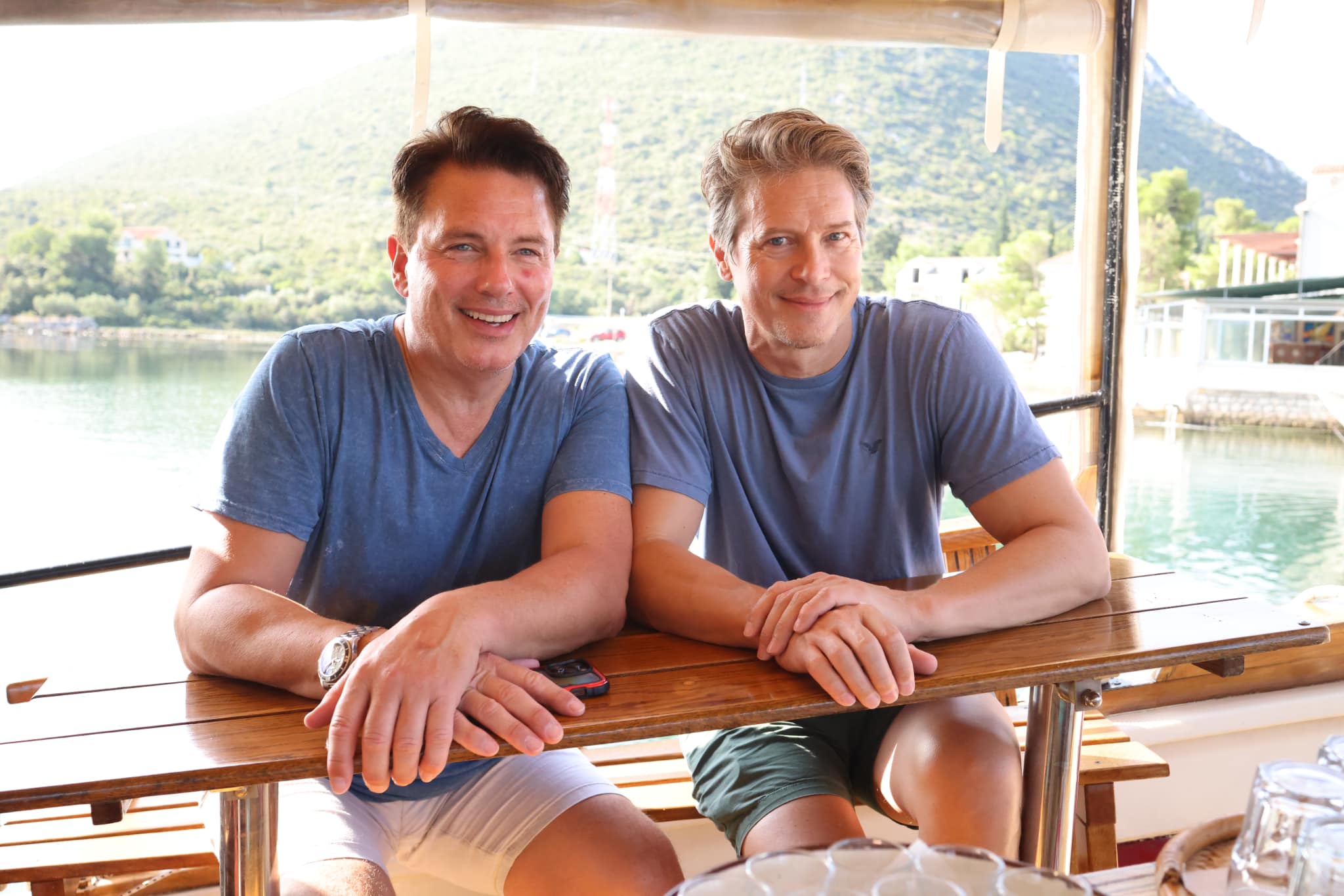 Two men sitting at a table on a boat.