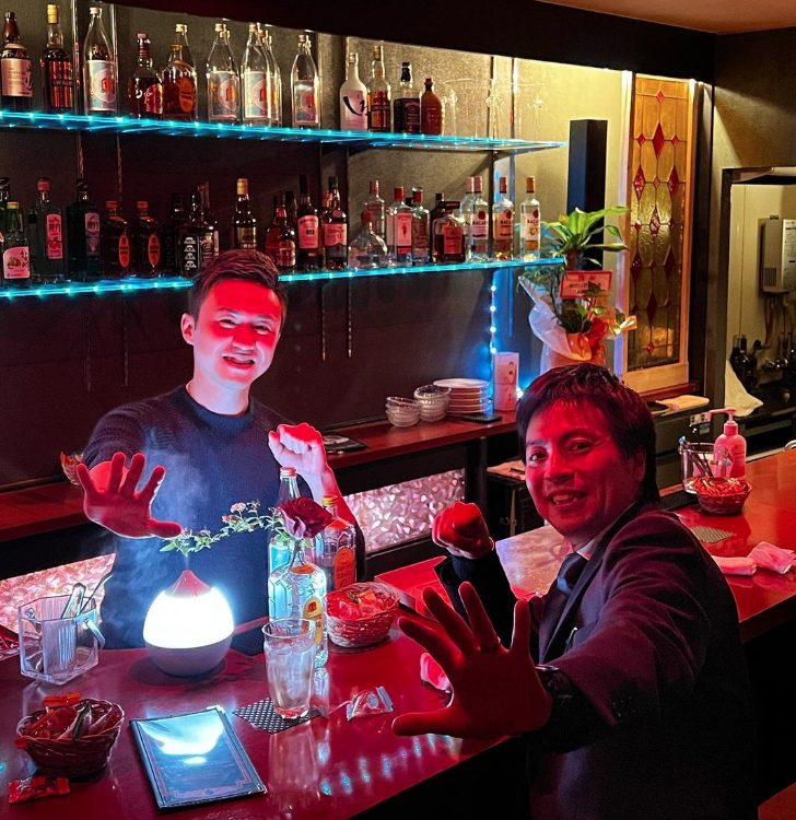 Aiki Tanaka behind the bar with a patron.