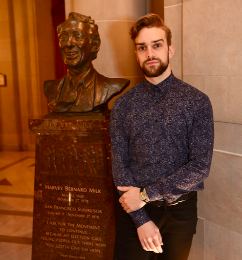 Gay dancer Myles Thatcher poses with a status of Harvey Milk in San Francisco's city hall.
