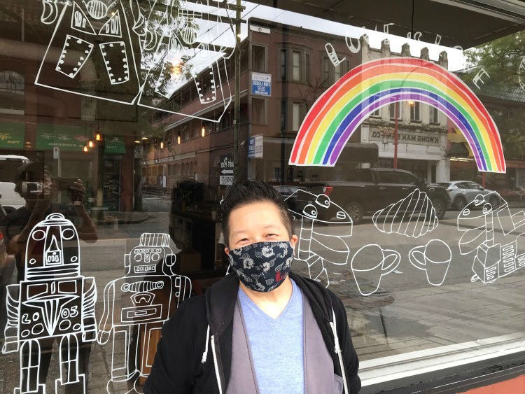 Candie Tanaka in front of his 'Love is Love' vinyl artwork on the window of Propaganda Coffee