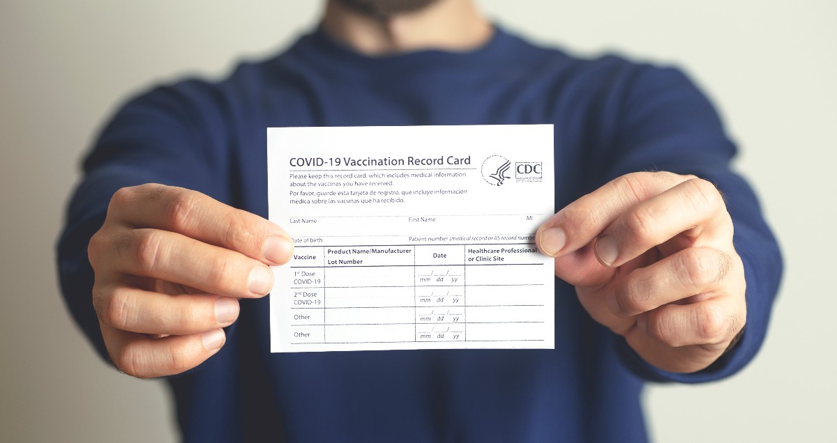 A man holds a vaccine card