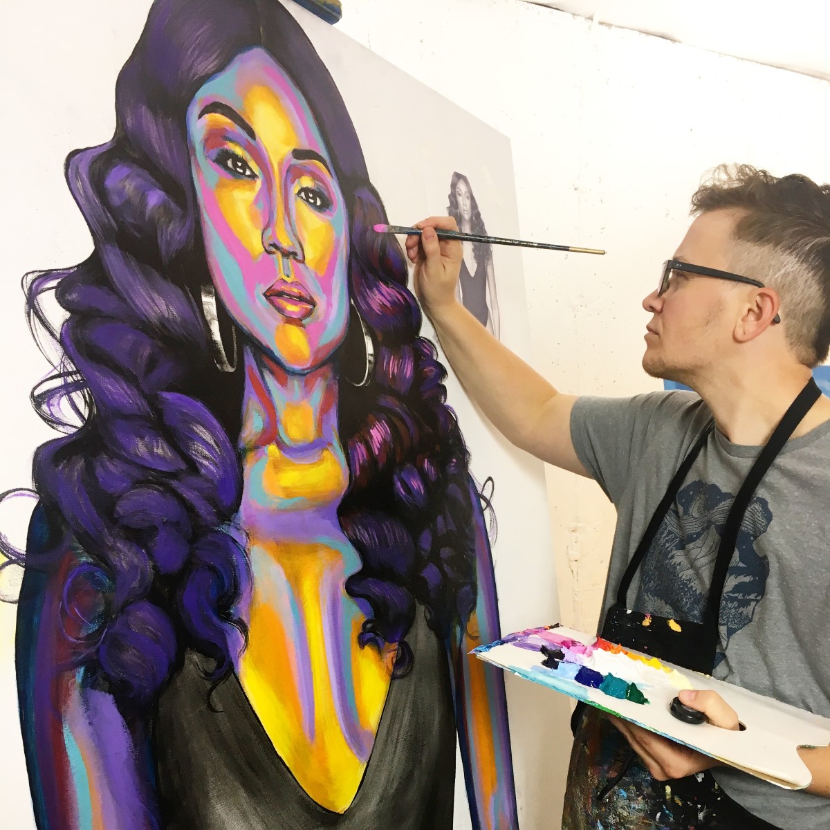 Trans artist Rae Senarighi at work on a portrait