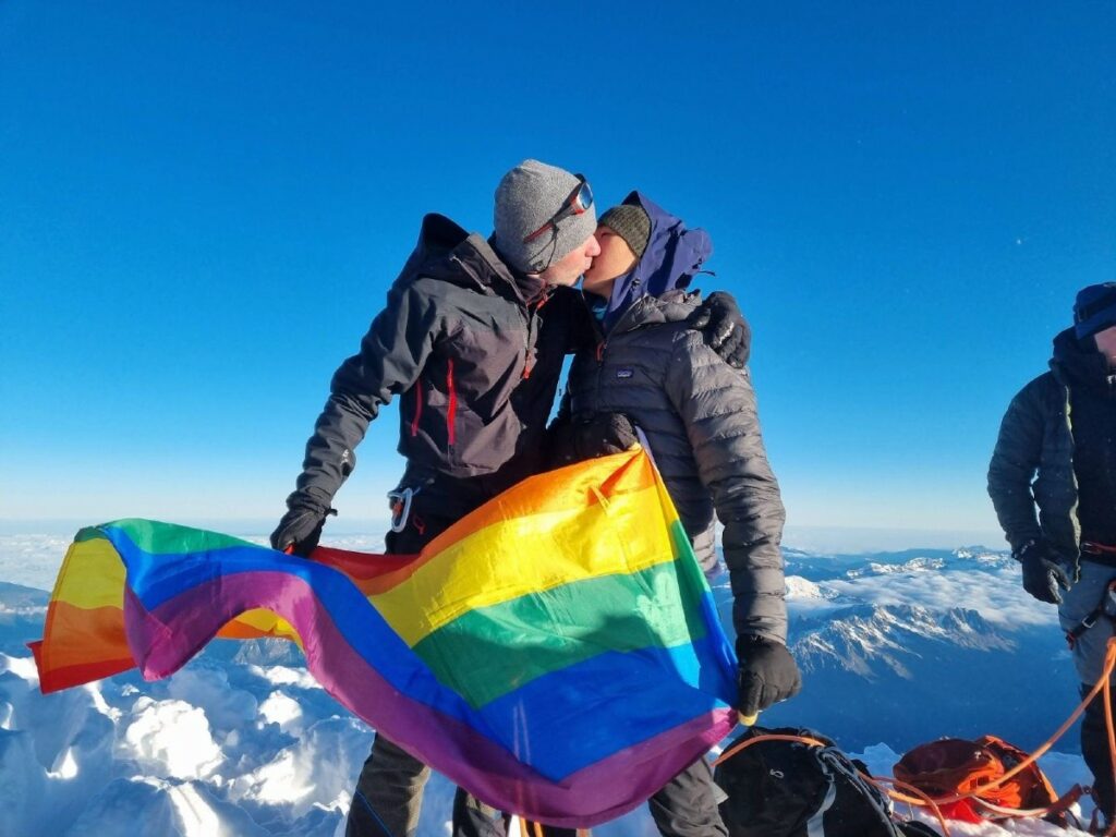 Two of the Pink Summits climbers kiss at the top of Mont Blanc